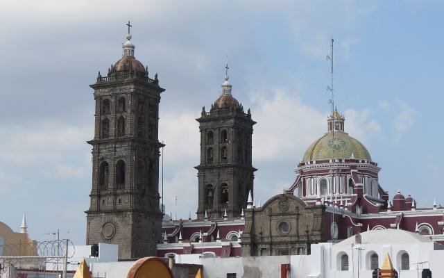 The bell towers and tiled dome of Puebla Cathedral above the rooftops of the historic centre