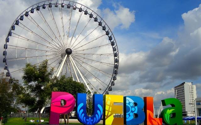 The Estrella de Puebla observation wheel behind the colourful PUEBLA letters