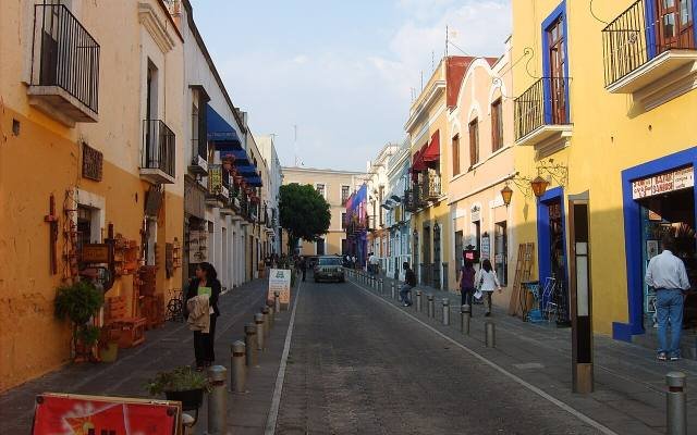 A cobbled street of yellow and orange colonial houses in the Barrio de los Sapos