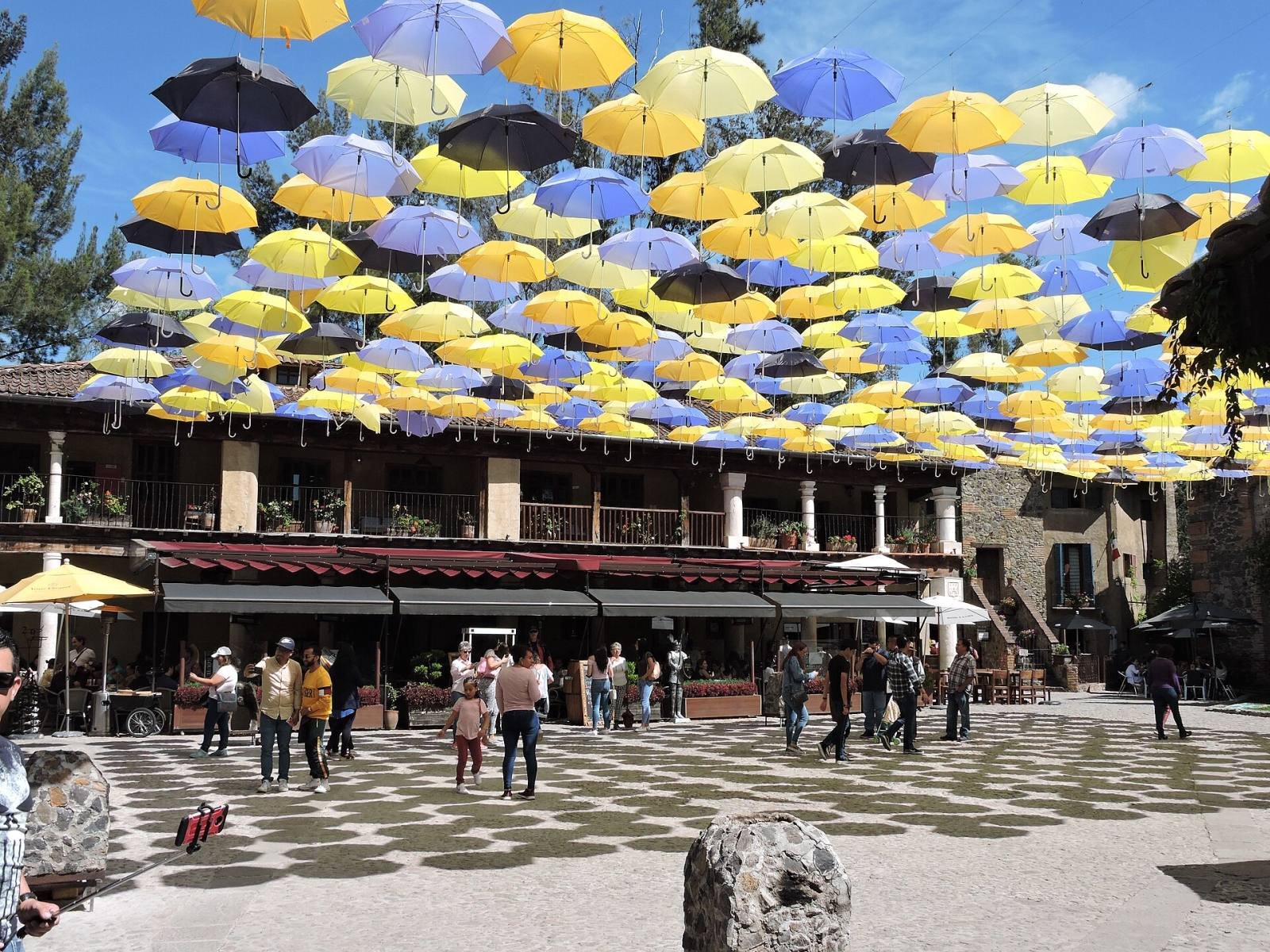 Rows of colourful umbrellas hanging above the main square of Val’Quirico