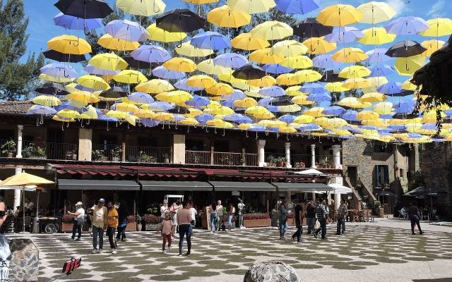 Rows of colourful umbrellas hanging above the main square of Val’Quirico