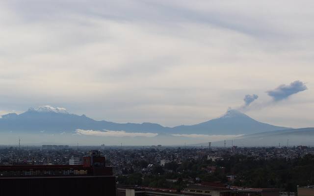 Popocatépetl and Iztaccíhuatl rising above the haze of the valley at dawn