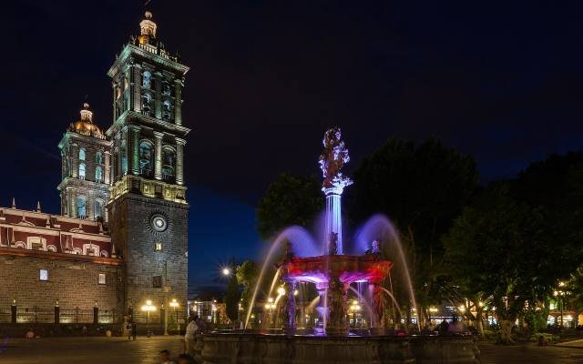 Puebla Cathedral and the lit fountain of the zócalo at night
