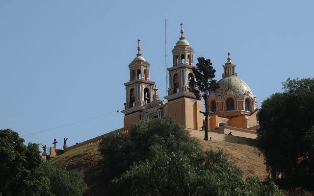 The church of Our Lady of Remedies on top of the Great Pyramid of Cholula, rising above the trees