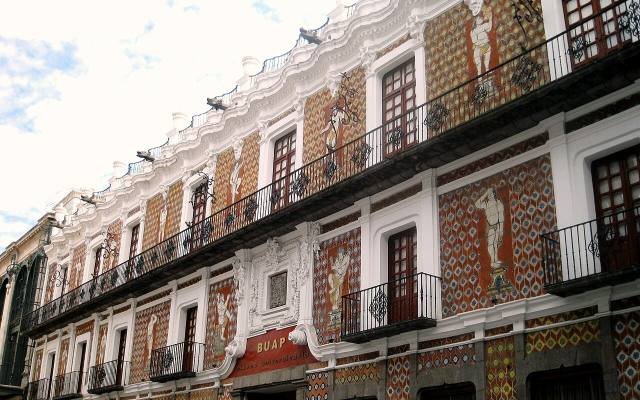 The tiled front of the Casa de los Muñecos, with painted figures and iron balconies